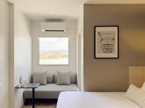 a bedroom with a bed and a window at Fortune D Hotel Loei in Loei