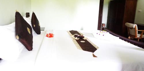 a bed with a white sheet with ties on it at Lamai Inn 99 Bungalows in Lamai