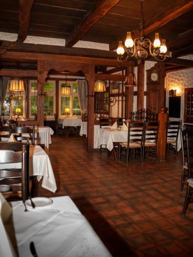 a dining room with tables and chairs and a chandelier at Heidehotel Waldhütte in Telgte