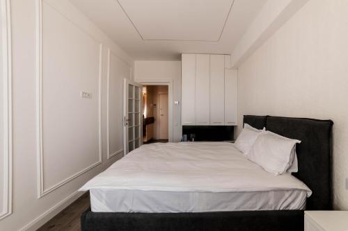 a bedroom with a large bed with white sheets and pillows at Cherry Apartments in Iaşi