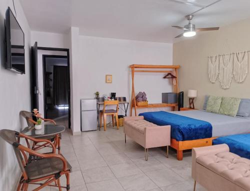 a bedroom with a large bed and a living room at Bokatrip Xochimilco in Oaxaca City