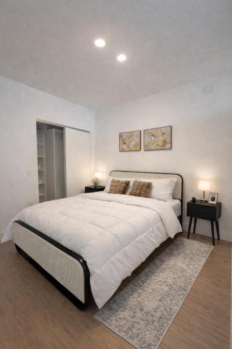 a large white bedroom with a large bed and two tables at Prime Miami location - Modern Skyline Stay in Miami