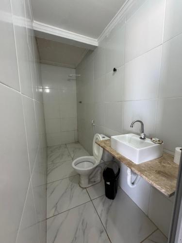 a bathroom with a sink and a toilet at Pousada beira mar e sol in Tibau