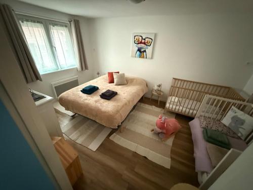 a small bedroom with a bed and a crib at Maison atypique Alsacienne in Kintzheim