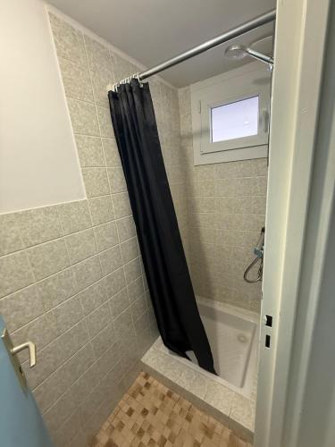 a bathroom with a shower with a black shower curtain at Maison atypique Alsacienne in Kintzheim