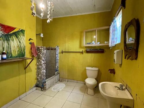 bagno giallo con servizi igienici e lavandino di Casa De Darwin a Lobitos
