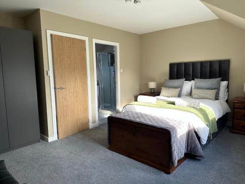 a bedroom with two beds and a wooden door at Coiseag at Maol Ruadh, Roy Bridge, near Ben Nevis in Roybridge