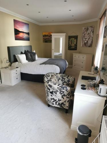 a bedroom with a bed and a chair in it at Arrochoile in Balmaha