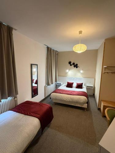 a hotel room with two beds and a chandelier at Le Saint Christophe in Cosne-Cours-sur-Loire