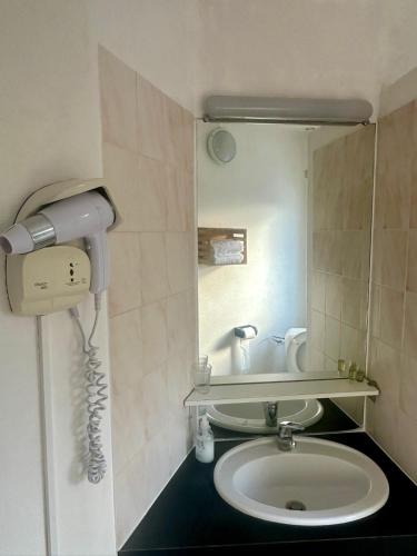 a bathroom with a sink and a phone on the wall at Le Saint Christophe in Cosne-Cours-sur-Loire