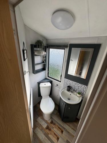 a small bathroom with a toilet and a sink at Trecco Bay Private rentals in Newton