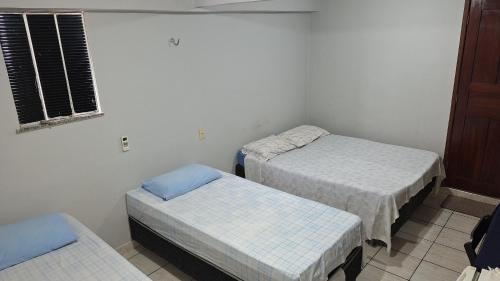a room with two twin beds and a window at Vera's Apart-Hotel & Restaurante in Belém