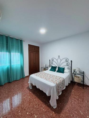 a bedroom with a large bed with green curtains at Alojamiento rural El Membrillo in Almodóvar del Río
