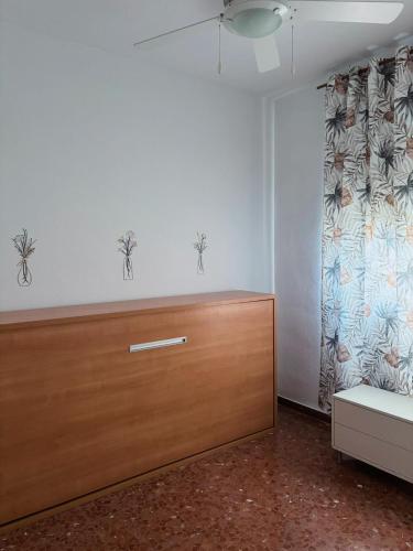 a room with a bed and a dresser and a curtain at Alojamiento rural El Membrillo in Almodóvar del Río