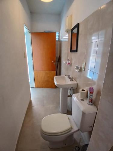 a white bathroom with a toilet and a sink at Linda Goya in Goya