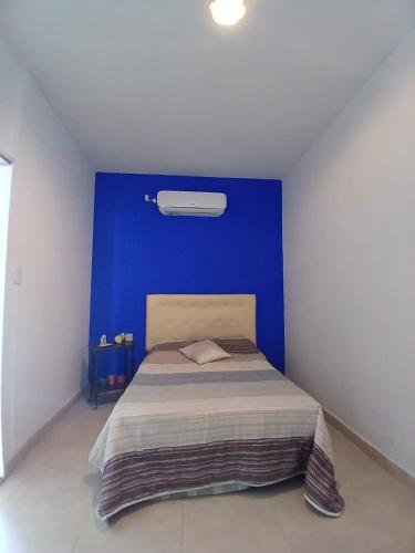 a bed in a room with a blue wall at Linda Goya in Goya