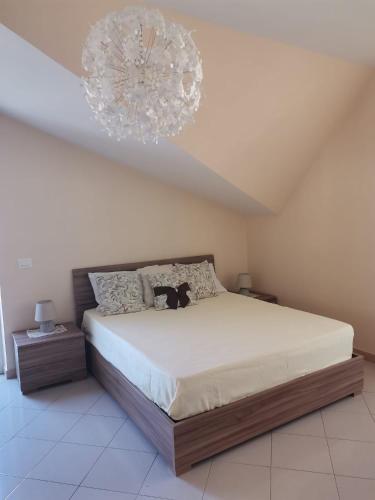 a bedroom with a large bed with a chandelier at La casa di Ely in Sarno