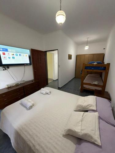 a bedroom with a large bed with a flat screen tv at Ana y Fran in Villa Zorraquín