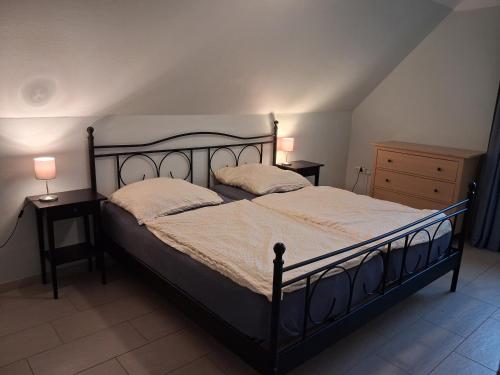 a bedroom with a large bed with two night stands at Strandrose in Friedrichskoog