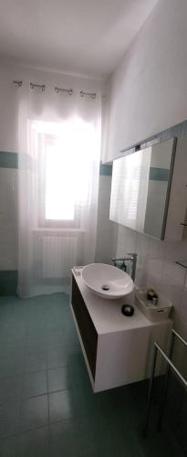 a white bathroom with a sink and a mirror at Casetta Mena in Sulmona