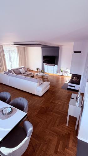 a large living room with a white couch and tables at Panorama Apartment in Nowy Targ