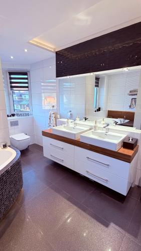 a large bathroom with two sinks and a toilet at Panorama Apartment in Nowy Targ