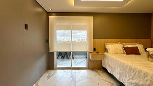 a bedroom with a bed and a window in it at Studio Red 10 - Sorocaba in Sorocaba