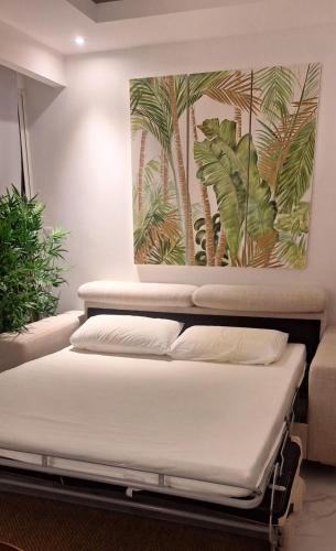 two beds in a room with a painting on the wall at Apartamento nuevo Cap Cana in Punta Cana