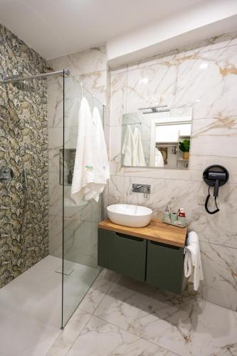 a bathroom with a sink and a shower at Kyma Apartment - Giardini Naxos in Giardini Naxos