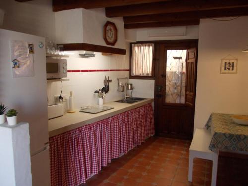 a kitchen with a red and white counter top at Tabarca - El rincón de la Muralla in Tabarca