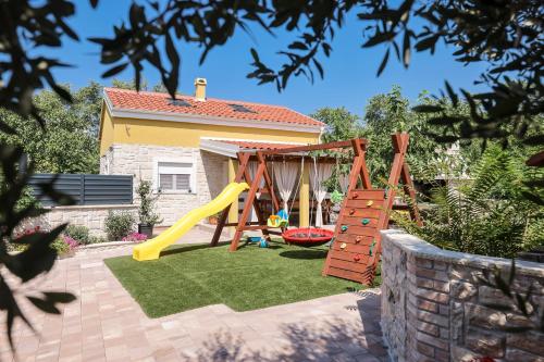 a backyard with a playground with a slide at Hidden Oasis - pool, playground - 3 min from the beach in Vir