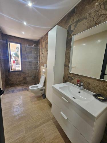 a bathroom with a sink and a toilet and a mirror at Villa in Aït Bou Zguia