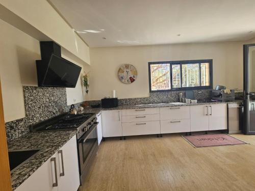 a kitchen with white cabinets and a counter top at Villa in Aït Bou Zguia