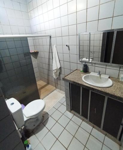 a bathroom with a toilet and a sink at Casa com piscina em Aldeia in Camaragibe