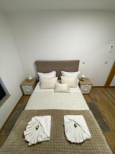 a bedroom with a large bed with white sheets and pillows at Casa Rodrigues in Terras de Bouro
