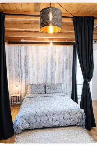 a bedroom with a canopy bed with a window at Le Cube in Drummondville