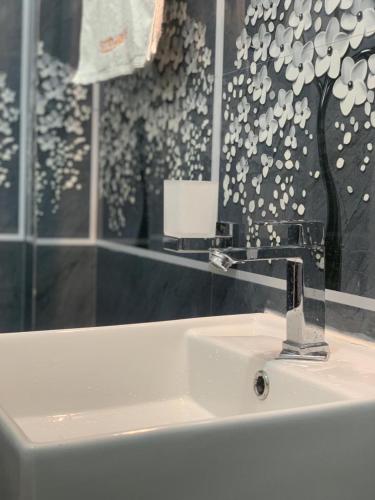 a bathroom sink with a faucet and a mirror at Nomin Villa in Kottagoda