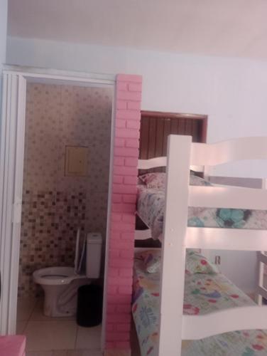 a bedroom with two bunk beds with pink bricks at Recanto do MIMI in Bertioga
