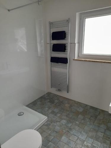 a bathroom with a toilet and a window at Stadtlounge Norden in Norden