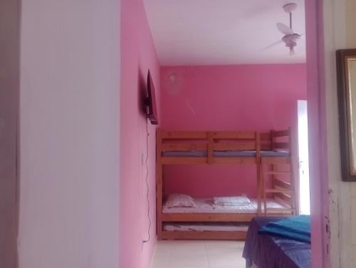 a bedroom with pink walls and a bunk bed at Recanto do MIMI in Bertioga