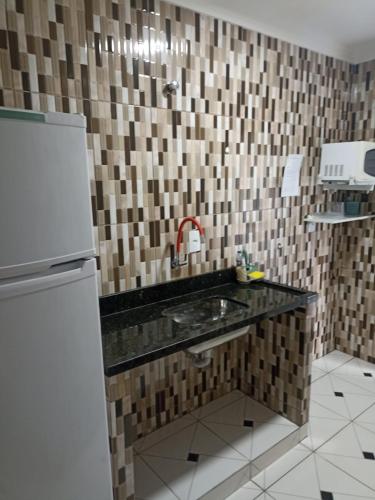 a kitchen with a sink and a refrigerator at Itu Loft Pousada Girassol in Itu