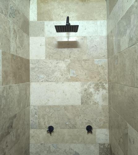 a tiled shower with a black basket in it at Hospedaje Don Juve in Atlixco