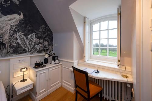 a small room with a desk and a window at Hotel Schloss Wilkinghege in Münster