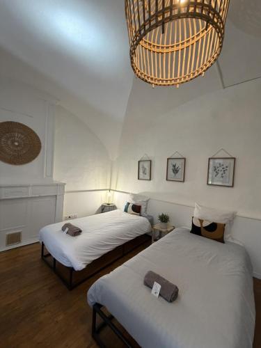 a bedroom with two beds and a chandelier at Les remparts in Chabeuil