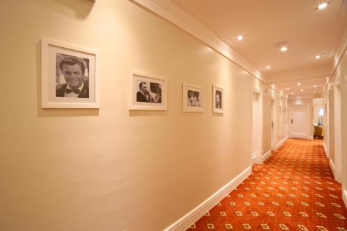 a hallway with framed pictures on the wall at Pousada Italia Eleganza in Campos do Jordão