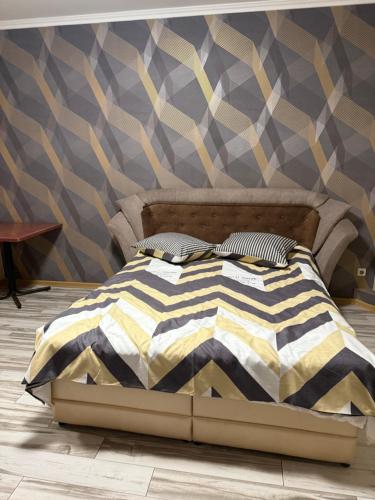a bed in a bedroom with a wall at Апартамент студия in Khmelnytskyi