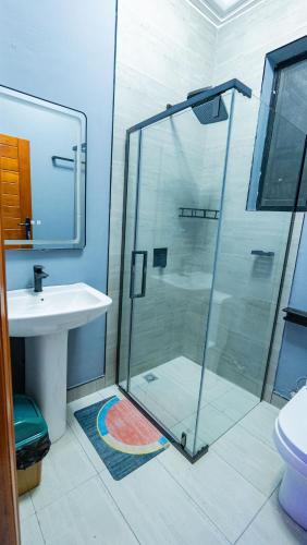 a bathroom with a glass shower and a sink at K&K Luxurious Landing in Limbe