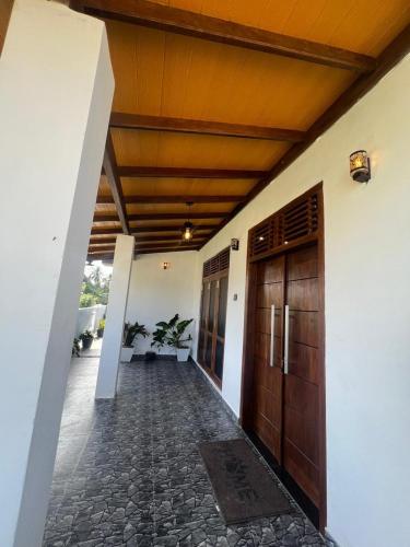 a hallway of a house with two wooden doors at Apollo Villa Weligama in Weligama