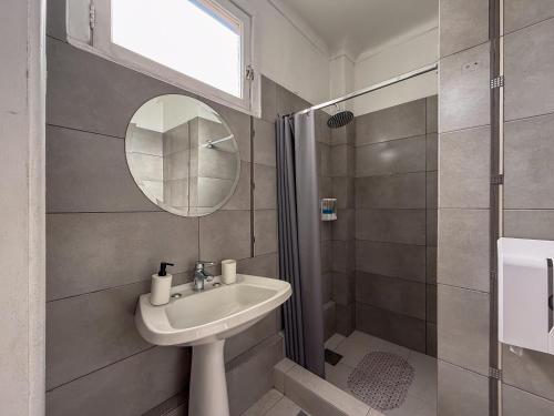 a bathroom with a sink and a mirror and a shower at Happy House Hostel in Santiago