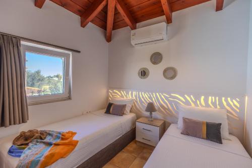 two twin beds in a room with a window at Villa Christalia in Kolymbia
